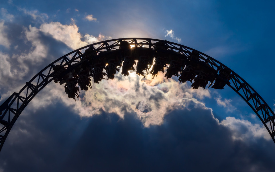 Achterbahn in einem Freizeitpark, mit Passagieren, die eine Looping fahren. 